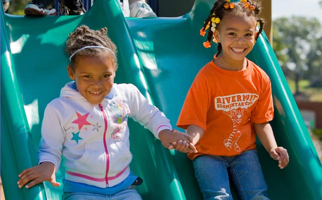 two sisters on a playground slide